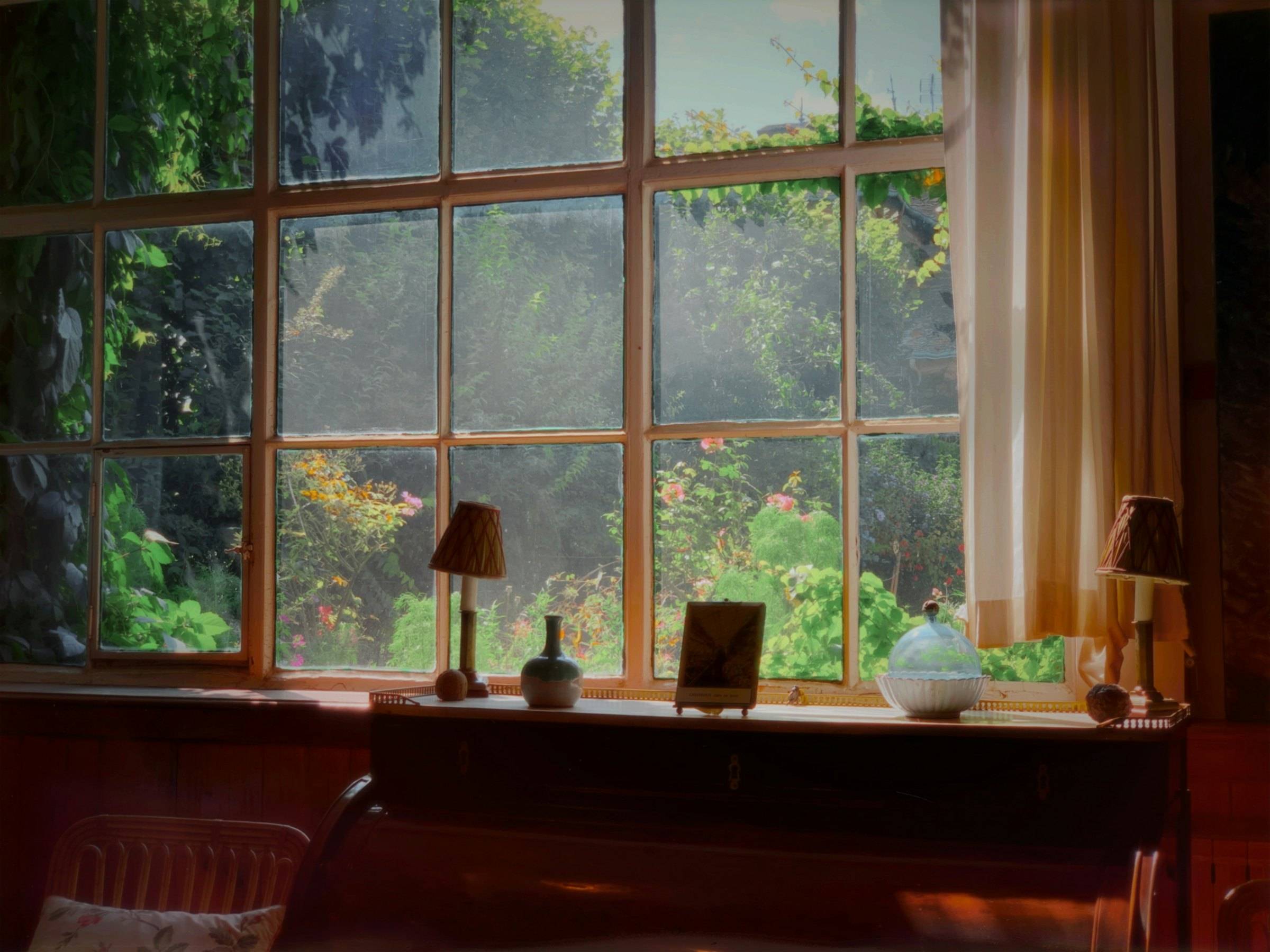 Sunlit windowsill with table lamps overlooking a garden