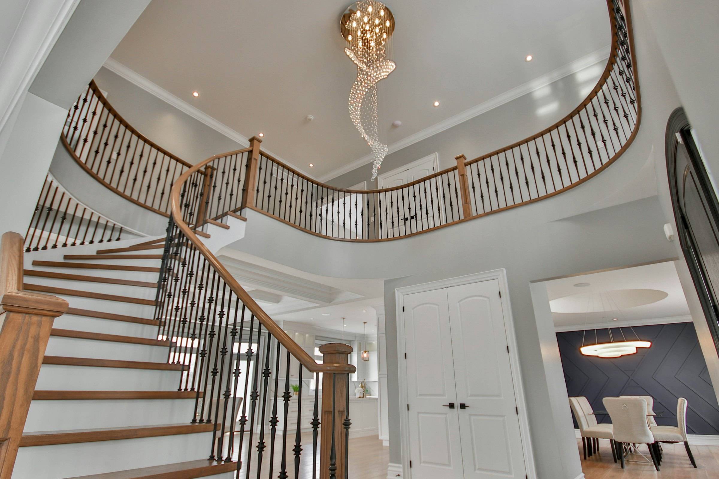 Curved staircase beneath a hanging chandelier